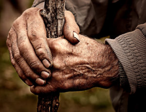 Elderly man holding a staff in his hands